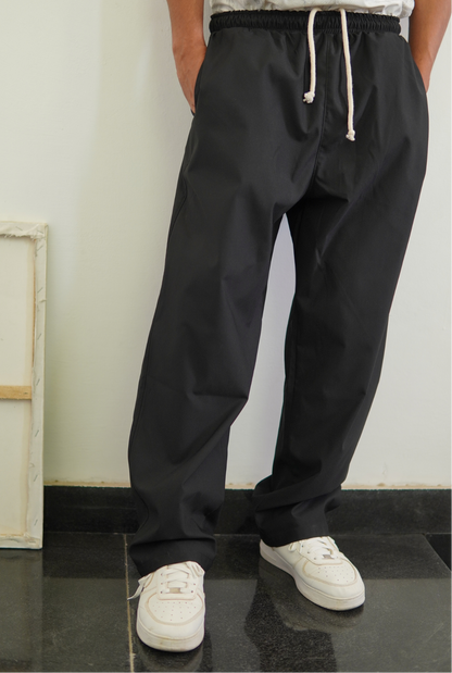 Person wearing black drawstring pants with a white background